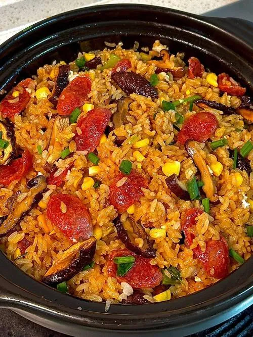 Claypot Rice — rice topped with cured meats in a sand pot, with a golden crispy crust at the bottom