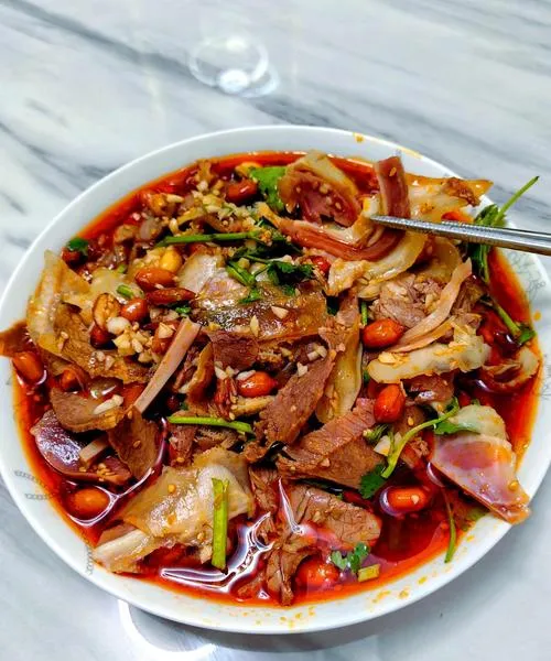 Fuqi Feipian — paper-thin beef and offal slices glistening in red chili oil, topped with sesame and crushed peanuts